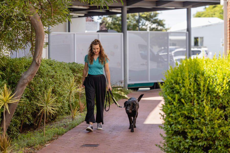 Victoria walks along a path with Onyx
